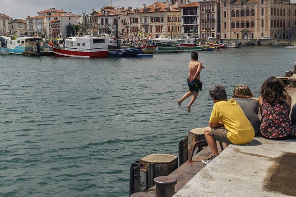 2014年6月25日 一组孩子看着一个男孩从码头跳进海里 — 图库照片