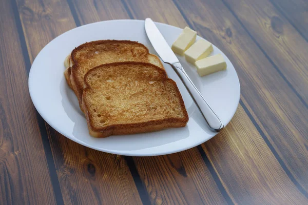 Brottoast Und Mehrere Scheiben Butter Auf Einem Teller Auf Einem — Stockfoto