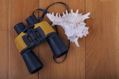 ahşap arka plan üzerinde modern binoküler ve deniz kabuğu Close-up