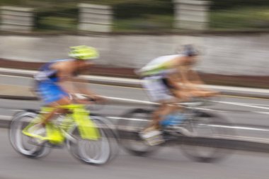 Bisikletçiler şehir bulanık bir arka plan üzerinde hareketli bulanık siluetleri