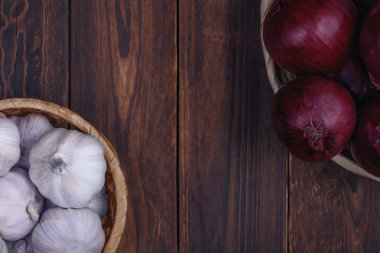 Sağlıklı beslenme kavramı. Sarımsak ve soğan ahşap arka plan üzerinde hasır sepetleri