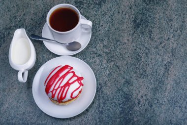 İştah açıcı taze çörek, bir fincan çay ve süt ahşap bir masa üzerinde bir sürahi. Kopya alanı ile üstten görünüm.