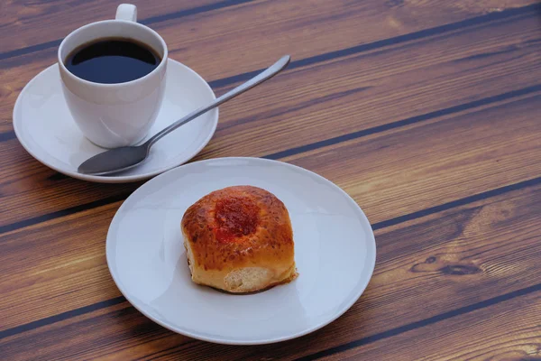 reçel ve bir fincan kahve ahşap bir masa üzerinde taze ev yapımı topuz