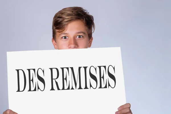 Egy Fiatal Férfi Egy Papírlapra Egy Felirat Francia Des Remises — Stock Fotó