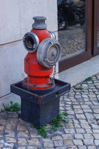 Red fire column on the street of Lisbon about the shopping center