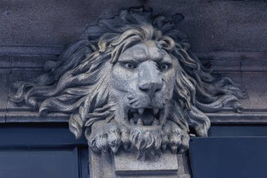 Portekiz'in Porto şehrinde bir binanın cephesinde bir aslan kafası mermer heykel