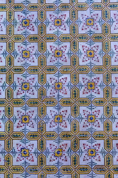 a fragment of the outer wall of a house in Lisbon decorated with ceramic tiles with a beautiful geometric patter