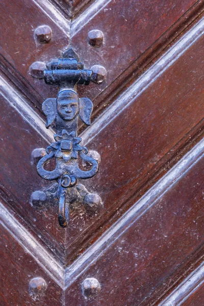 metal door handle in the form of a human head with large ears on the door in the German town of Rothenburg ob der Tauber