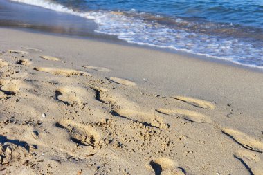 Akdeniz kıyılarında kumlu bir plajda yalınayak ayak izleri
