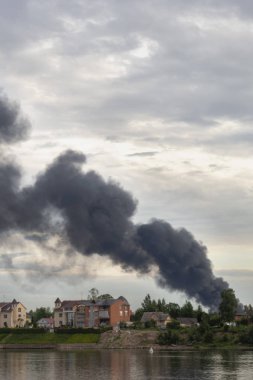 Yanan bir evden gelen tehlikeli bir kara duman bulutu akşam gökyüzünün arka planına karşı bir arka plan olarak