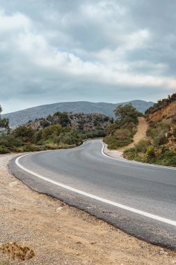 Alman Alpleri 'nin dağlarında asfalt yol ormanların, dağların ve bulutlu gökyüzünün arka planına karşı.