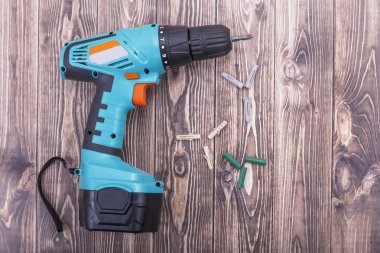 Modern kablosuz tornavida ve tahta arka planda plastik kaplamalar