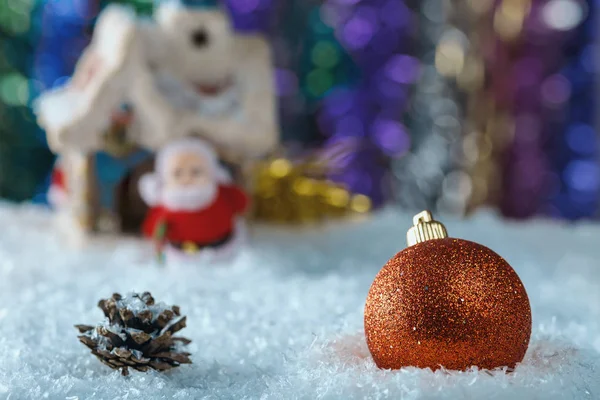 Christmas composition with a big red ball and Christmas toys on background artificial snow