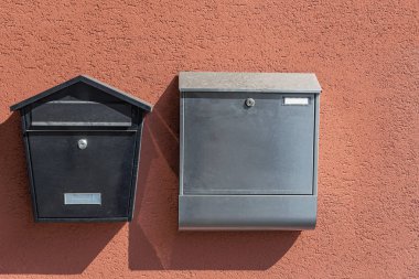 Alman şehri Braubach 'ta bir evin duvarında iki modern posta kutusu.