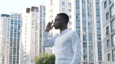 Genç, karizmatik, yakışıklı siyah erkek, dışarıda tek başına poz veren, mutlu, yakışıklı, zeki, genç girişimci, lider, menajer.