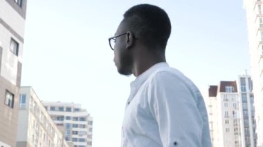 Genç, karizmatik, yakışıklı siyah erkek, dışarıda yalnız poz veriyor, fotoşop yapıyor, mutlu, yakışıklı, zeki, genç girişimci, lider yönetici.