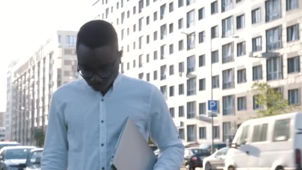 Portrait of young serious Confident black businessman freelancer worker holding laptop looking at camera and putting off glasses on the street, ready to work, concept of business — Stock Video