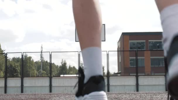 Kvinnlig basketspelare i shorts och vita strumpor på professionell bana kör med boll och framgångsrikt tina bollen till nätet. Handhållna bilder. Utomhus — Stockvideo