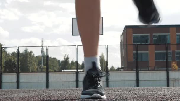 Αθλητική λεπτή νεαρή γυναίκα μπασκετμπολίστας άσκηση στο γήπεδο σε ανοιχτό χώρο, προπόνηση πριν από το παιχνίδι μπάσκετ, κάνοντας αθλητισμό, κάμψη των μυών των ποδιών — Αρχείο Βίντεο