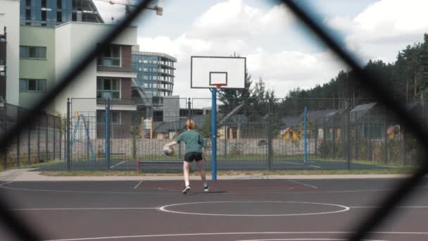 Schöne junge Frau spielt Basketball und scheitert, Ball fehlt Reifen, übt morgens im Park — Stockvideo
