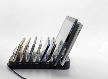 Beyaz arkaplanda akıllı telefonlar ve tabletler için büyük bir şarj cihazının yan görünümü