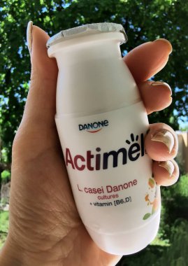Ağaçların arka planında Actimel yoğurdu var.