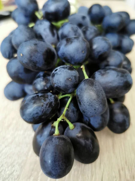 木のテーブルの上に濃い熟したブドウ — ストック写真