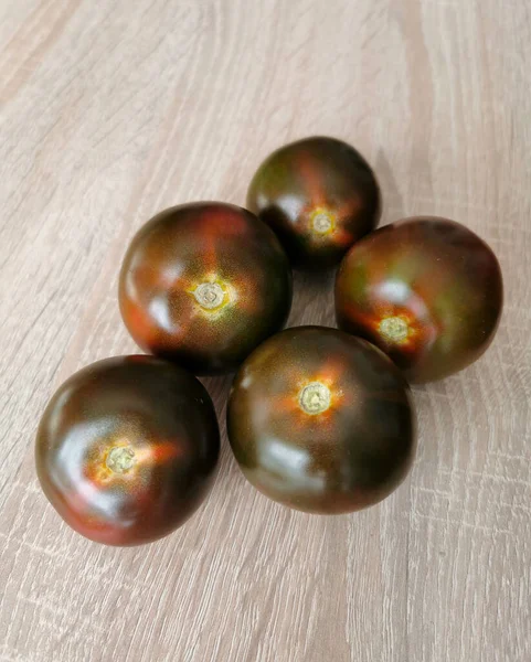 Fünf Frische Dunkelrote Tomaten Auf Einem Holztisch — Stockfoto
