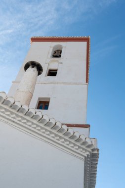 Güney İspanya 'da bir kasabanın kilisesi, kilisenin beyaz bir cephesi var, camları var, camları var, çanı var, baca borusu var