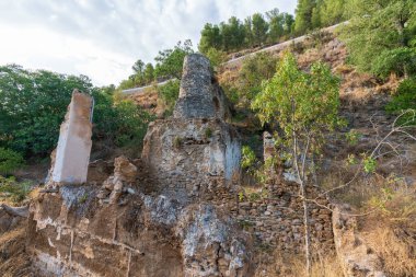 Güney İspanya 'daki bir un değirmeninin kalıntıları, inşaat taş ve çamurdan yapılmış, çevrede bitki ve ağaçlar var.