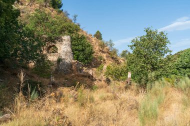 Güney İspanya 'daki bir un değirmeninin kalıntıları, inşaat taş ve çamurdan yapılmış, çevrede bitki ve ağaçlar var.
