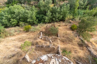 Güney İspanya 'daki bir un değirmeninin kalıntıları, inşaat taş ve çamurdan yapılmış, çevrede bitki ve ağaçlar var.