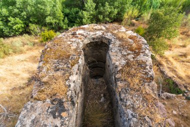Hendek eski un değirmenine su getirmek için, hendek taş ve çimentoyla inşa edildi, çevrede bitki örtüsü var.
