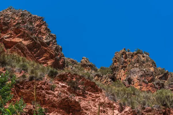 Güney İspanya 'nın dağlık bölgesi, bol bitki örtüsü var, dağın kayalık oluşumları var ve gökyüzü açık.