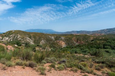 Güney İspanya 'nın dağlık bölgesi, bol bitki örtüsü var, gökyüzünde bulutlar var.