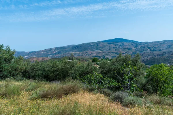 Güney İspanya 'nın dağlık bölgesi, bol bitki örtüsü var, gökyüzünde bulutlar var.
