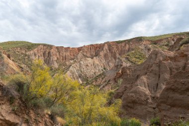Güney İspanya 'nın dağlık arazisi, dağlar aşırı derecede aşınmış, yarı çöl bölgesi, taşlar ve çalılar var ve gökyüzü bulutlu.
