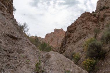 Güney İspanya 'nın dağlık arazisi, dağlar aşırı derecede aşınmış, yarı çöl bölgesi, taşlar ve çalılar var ve gökyüzü bulutlu.
