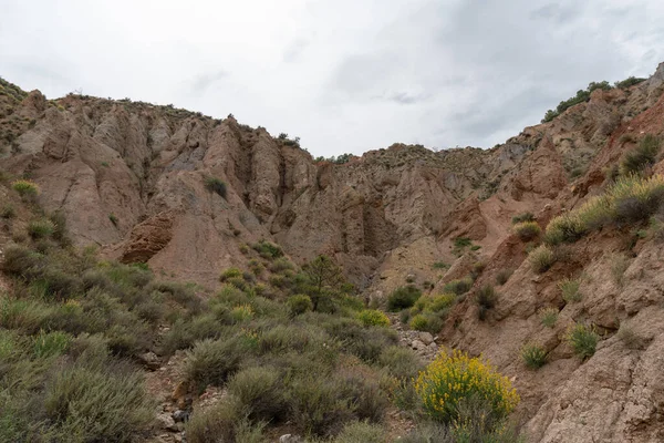 Güney İspanya 'nın dağlık arazisi, dağlar aşırı derecede aşınmış, yarı çöl bölgesi, taşlar ve çalılar var ve gökyüzü bulutlu.