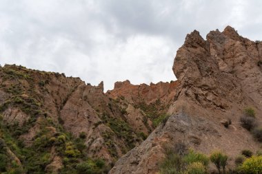 Güney İspanya 'nın dağlık arazisi, dağlar aşırı derecede aşınmış, yarı çöl bölgesi, taşlar ve çalılar var ve gökyüzü bulutlu.