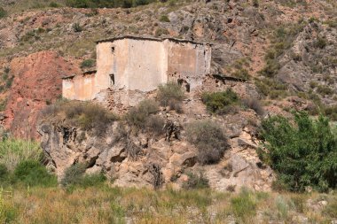 İspanya 'nın güneyinde dağlık bir arazi. Sazlık ve ağaçların bol olduğu bir nehir var. Büyük bir kayanın tepesinde terk edilmiş bir çiftlik evi var.