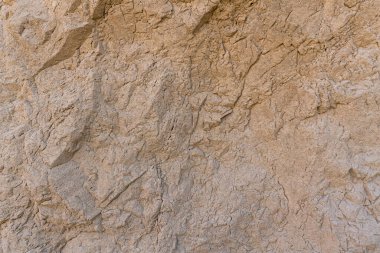 Düz olmayan yüzey kahverengi kaya duvarı, bir sürü çatlak var.