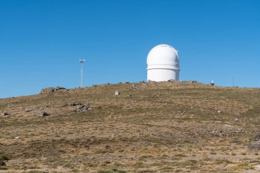 Almerya 'da (İspanya) Calar Alto astronomik teleskopu, yerde bitki örtüsü, kayalar ve gökyüzü açık.