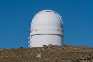 Almerya 'da (İspanya) Calar Alto astronomik teleskopu, yerde bitki örtüsü, kayalar ve gökyüzü açık.