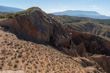İspanya 'nın güneyindeki dağlık arazi, dağlar çalı bitkileriyle kaplı, çorak bir arazi, arazi farklı tonlara sahip, gökyüzü temiz.