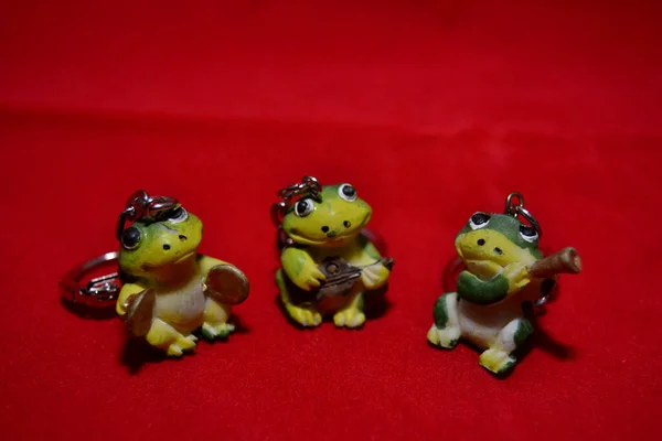 The three lucky frogs playing musical instruments