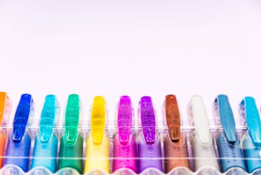 Jel kalemler leylak bir arka plan üzerinde izole çeşitli renk kümesi