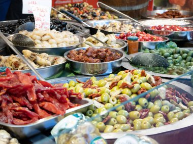 Güney İtalya Catania 'nın tipik ürünlerine yakın çekim. Bu baharatlı zeytinlerin, yağlı enginarların, kurutulmuş domateslerin ve diğer lezzetli Sicilya spesiyallerinin arasında. Yatay görünüm