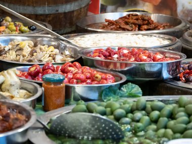 Güney İtalya Catania 'nın tipik ürünlerine yakın çekim. Bu baharatlı zeytinlerin, yağlı enginarların, kurutulmuş domateslerin ve diğer lezzetli Sicilya spesiyallerinin arasında. Yatay görünüm