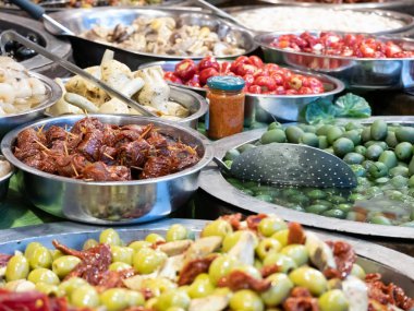 Güney İtalya Catania 'nın tipik ürünlerine yakın çekim. Bu baharatlı zeytinlerin, yağlı enginarların, kurutulmuş domateslerin ve diğer lezzetli Sicilya spesiyallerinin arasında. Yatay görünüm